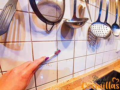 limpiando las juntas de los azulejos con un cepillo de dientes